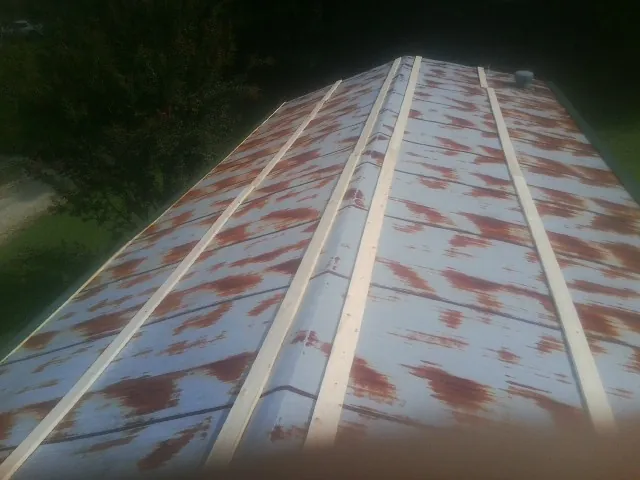 Rusted metal roof panels with new wood purlins before replacement — Storm Damage Roof Repair in New Site by Roofing Brothers
