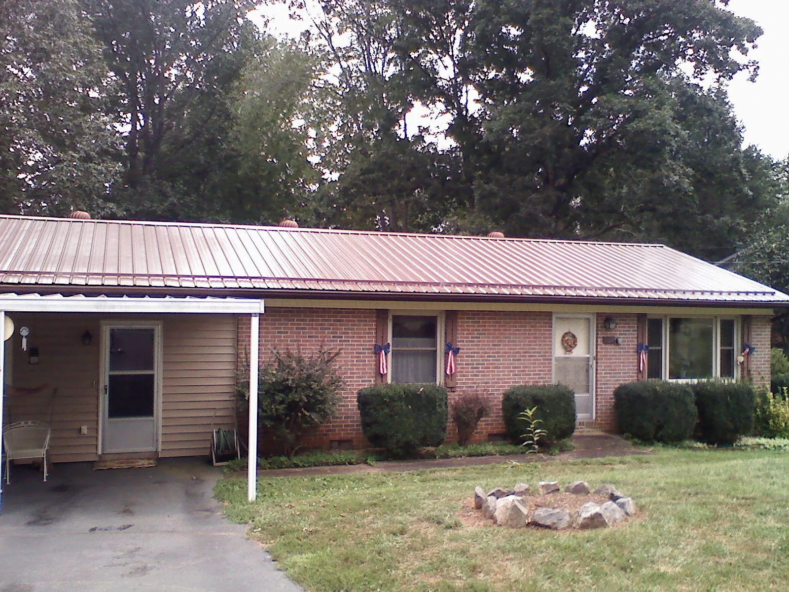Bronze metal roof and carport on a brick ranch home — Roof Repair work by our crew in New Site